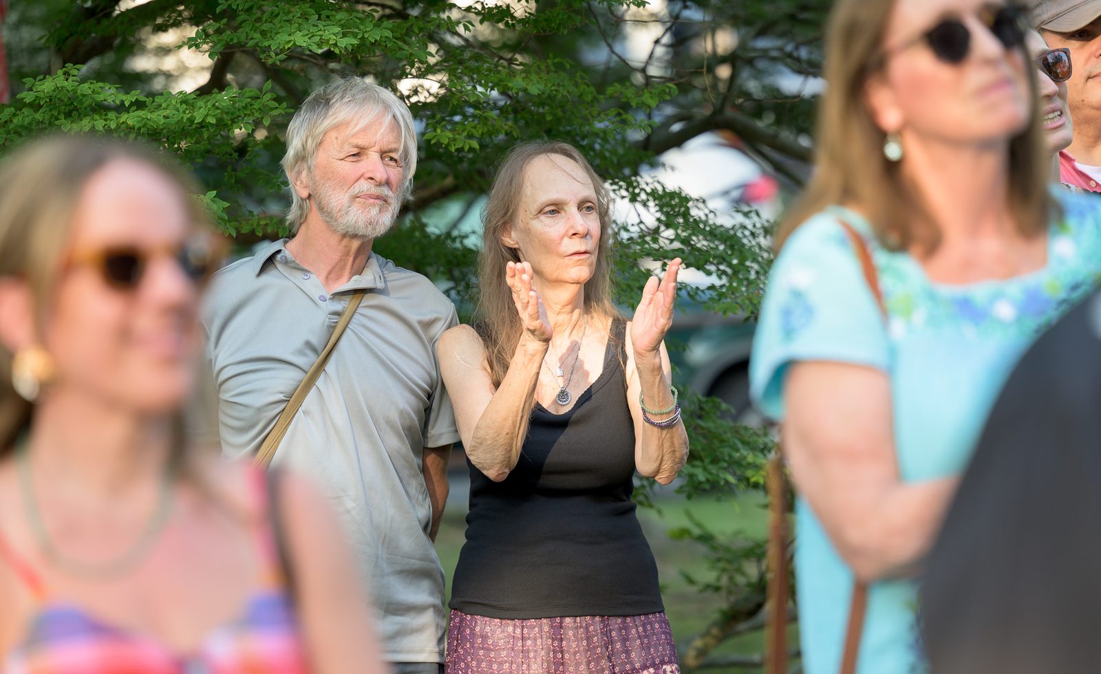 An audience member applauds during the outdoor ceremony.