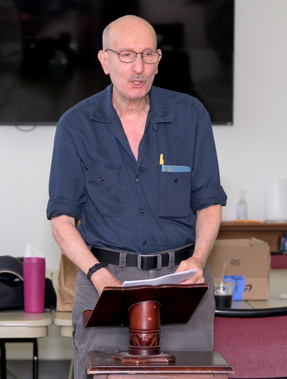 Marc Levy reads from loose pages at the lectern during a session on the literature of the Vietnam War.