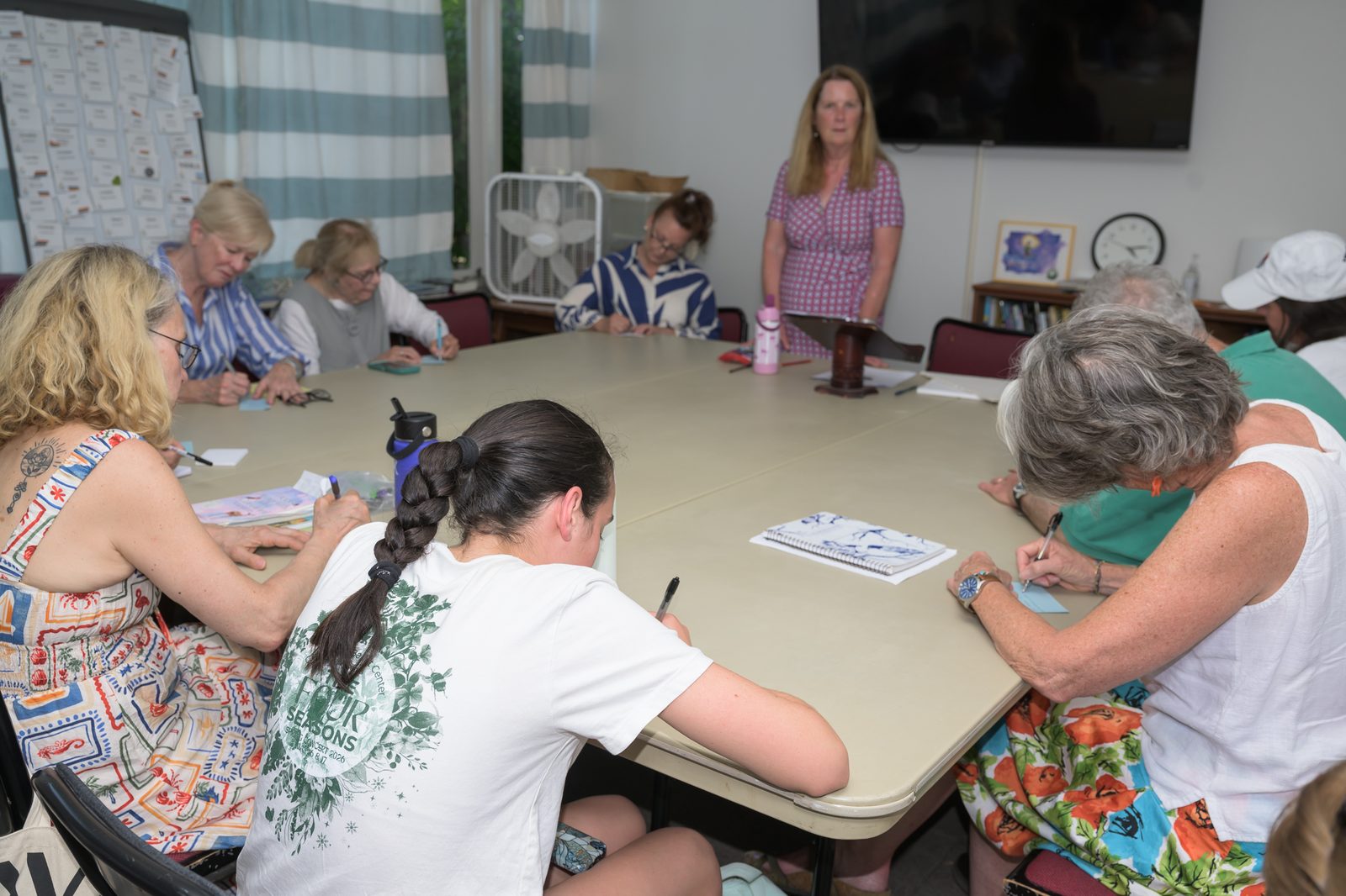 Writers young and old bend over their pages as Áine Greaney leads a workshop exercise.