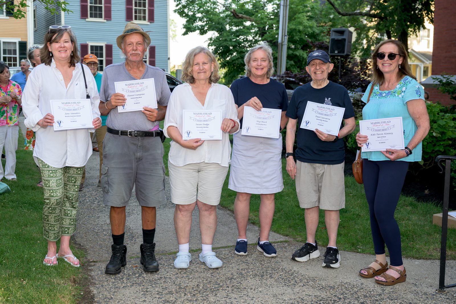 Sculpture category winners, including Best of Show recipient Kiki Taron Kinney, line up with their awards.