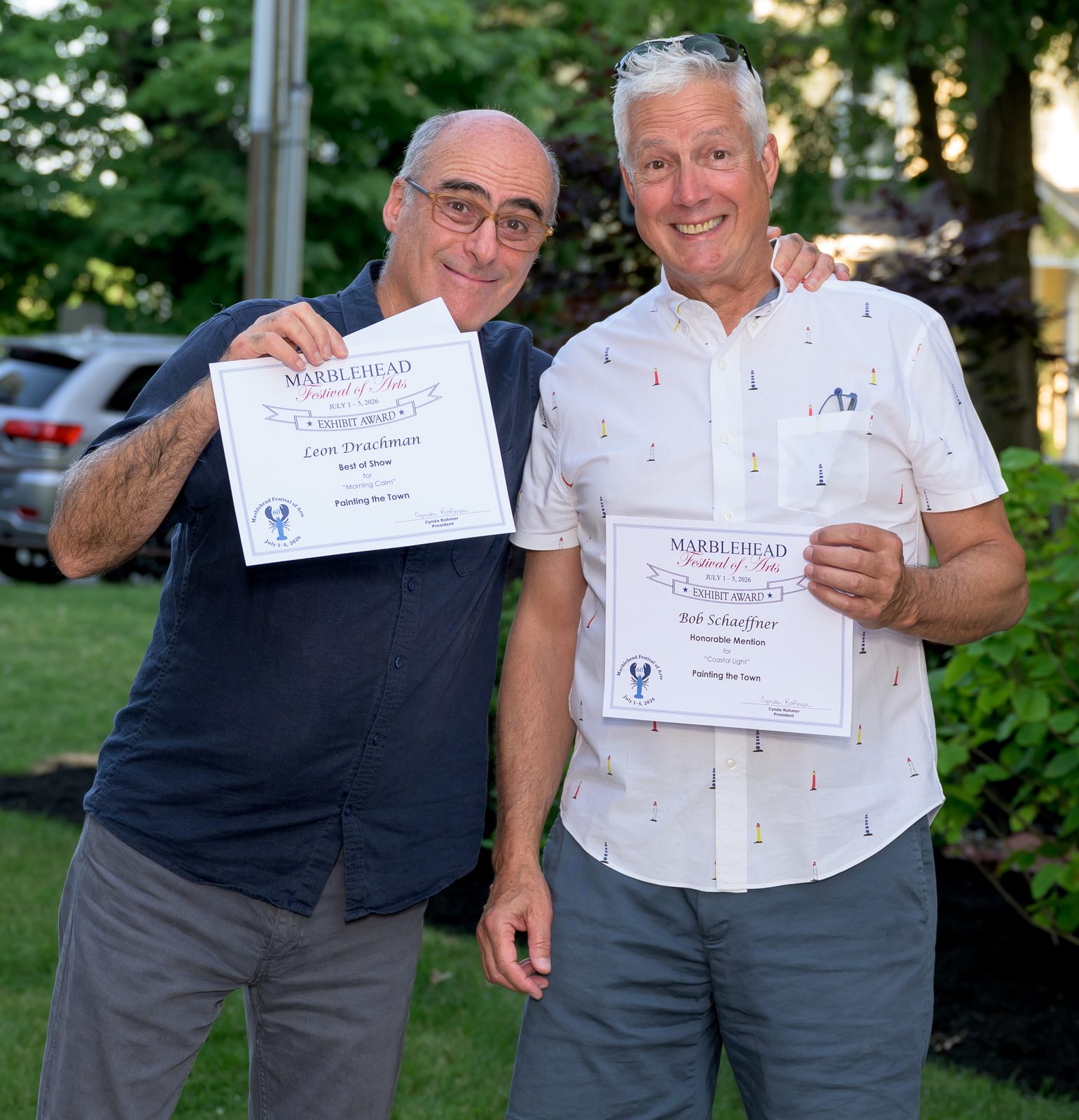 Two Painting the Town winners show their certificates — Best of Show for ‘Morning Calm’ and an honorable mention for ‘Coastal Light.’