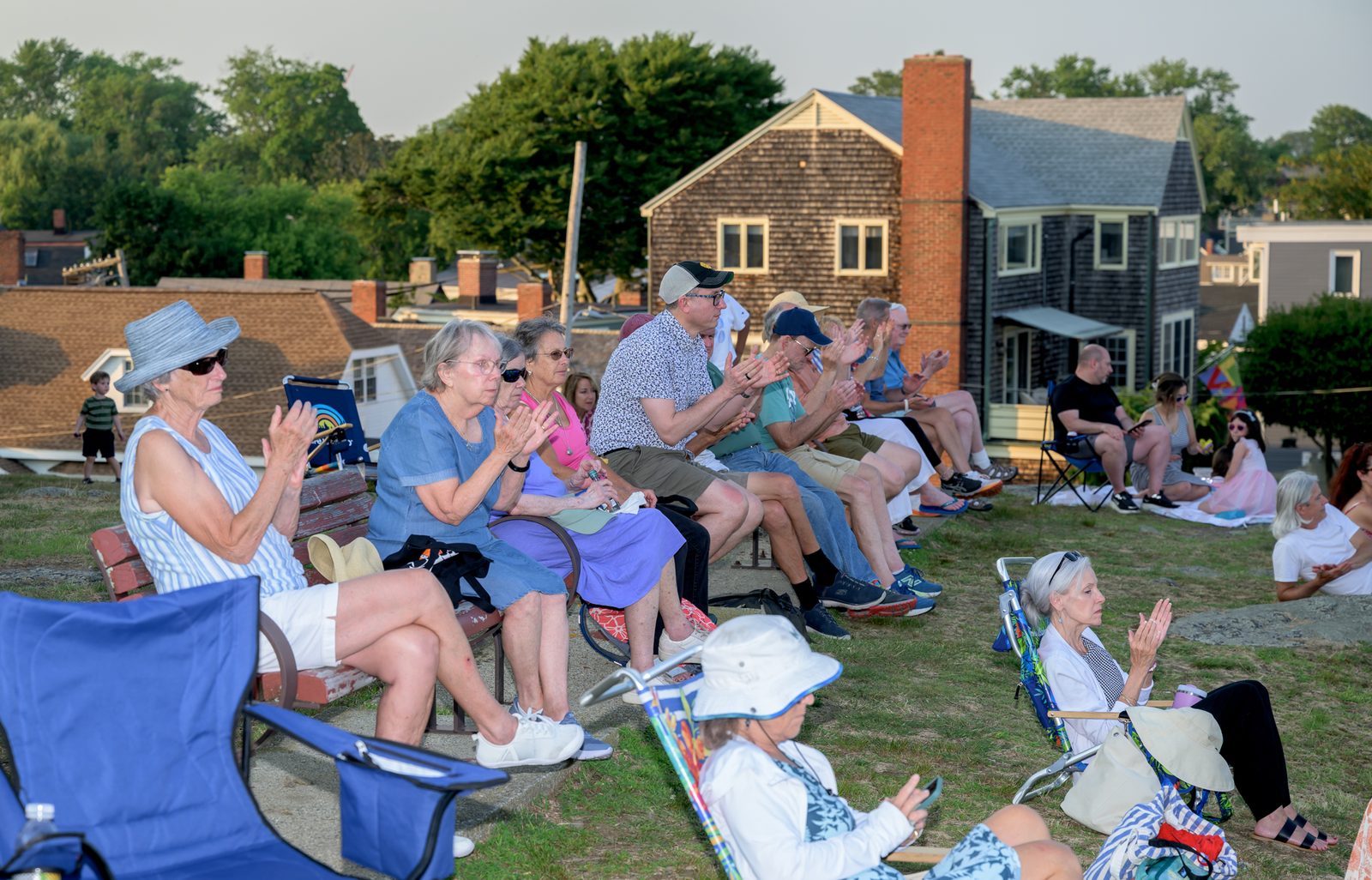 Audience members applaud from benches and beach chairs on the rise at Crocker Park.