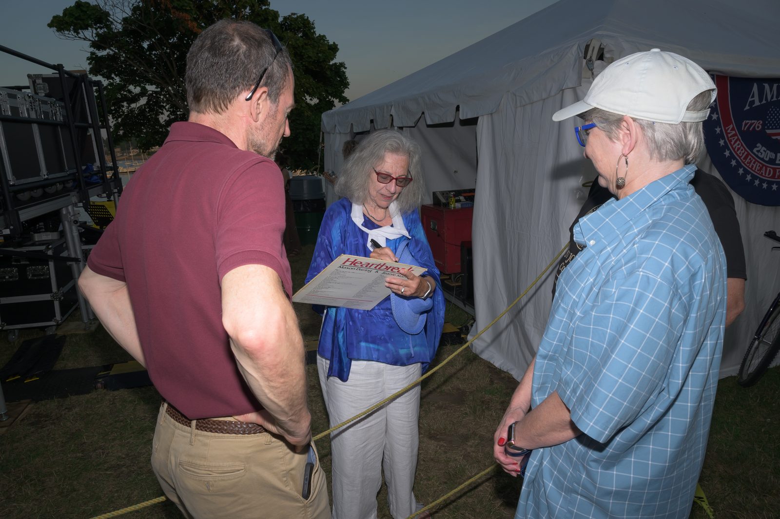 Jeanie Stahl autographs a fan’s vintage copy of ‘Heartbreak,’ the LP she recorded with Mason Daring, beside the hospitality tent.