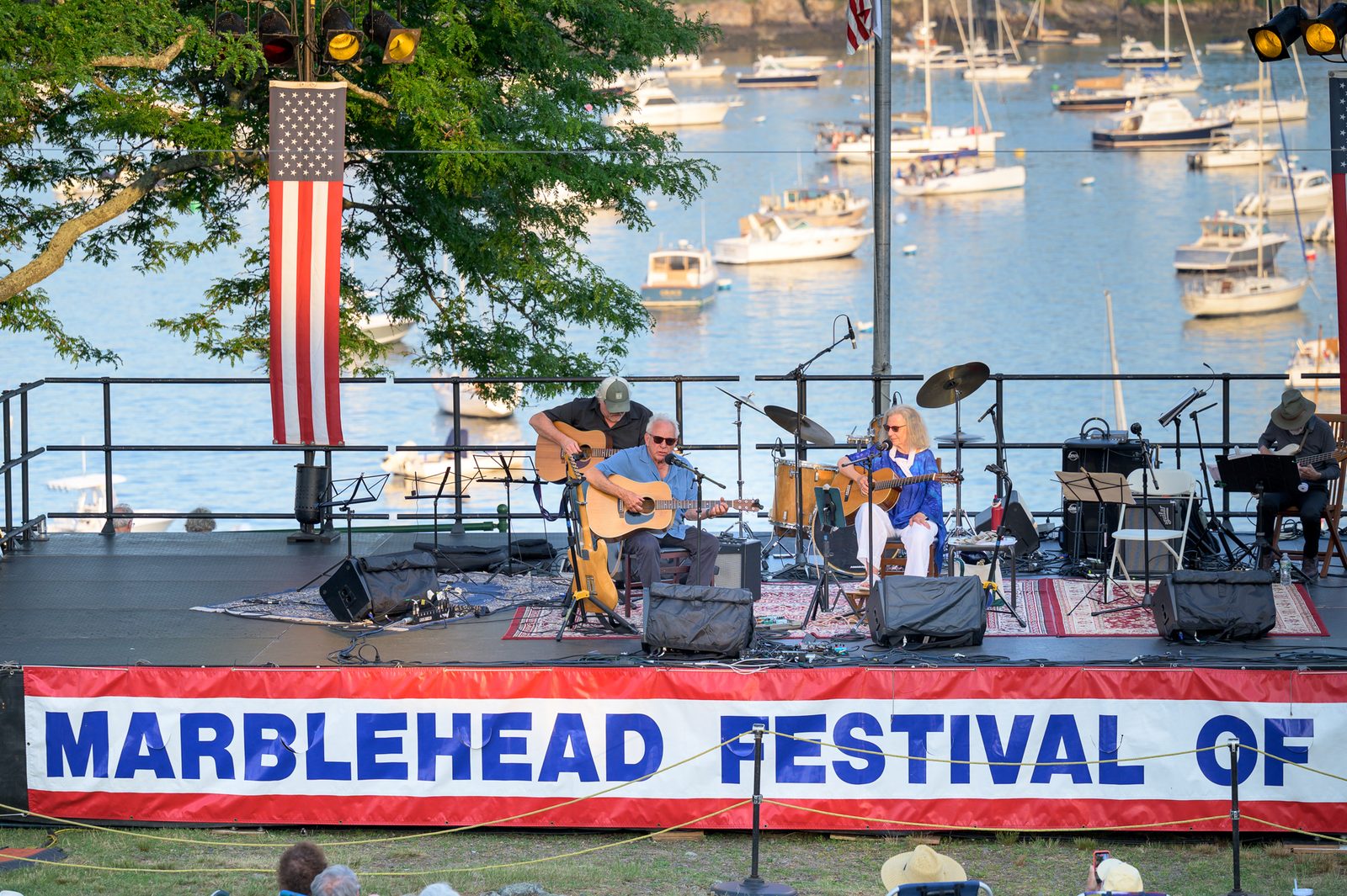 Mason Daring and Jeanie Stahl perform on the Crocker Park stage above a harbor full of moored boats.