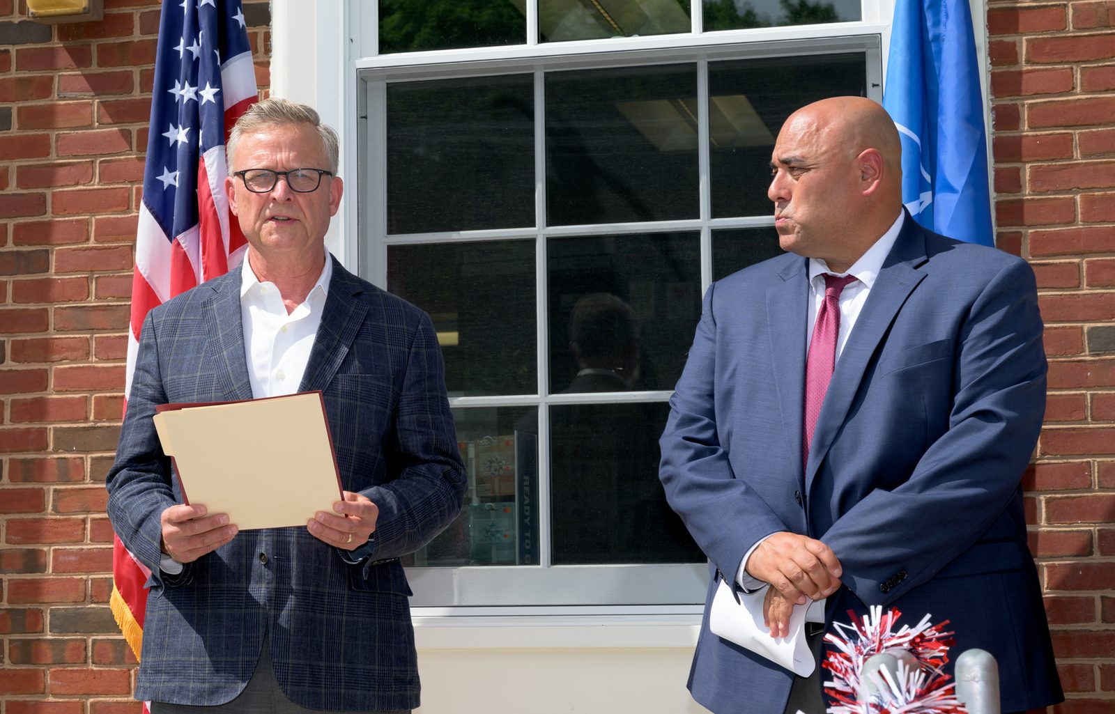 Select Board member Moses Grader reads a proclamation outside the post office as Postmaster Chris King looks on.