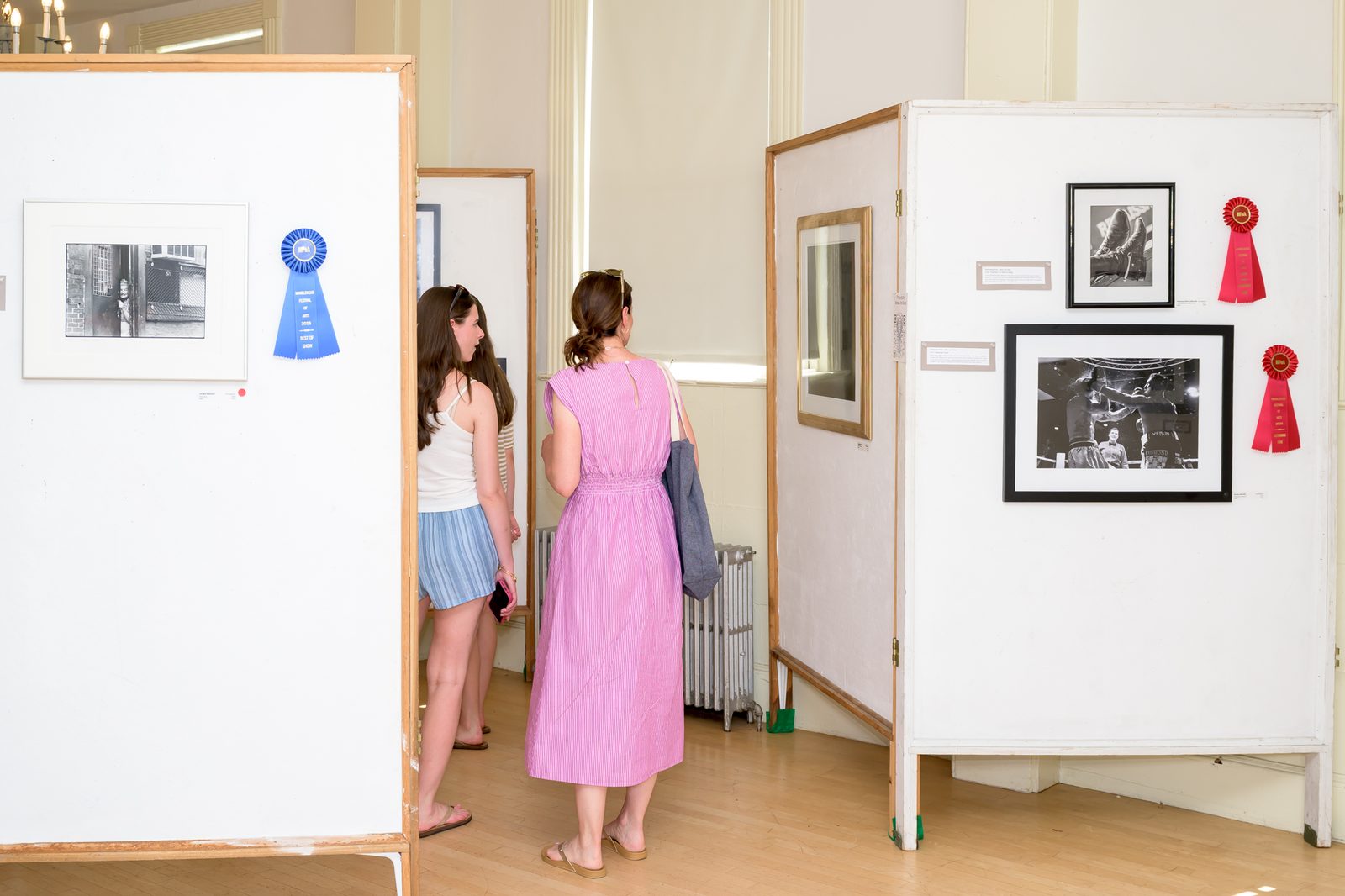 Visitors pause beside the Best of Show winner in the photography exhibit in the Old Town House.