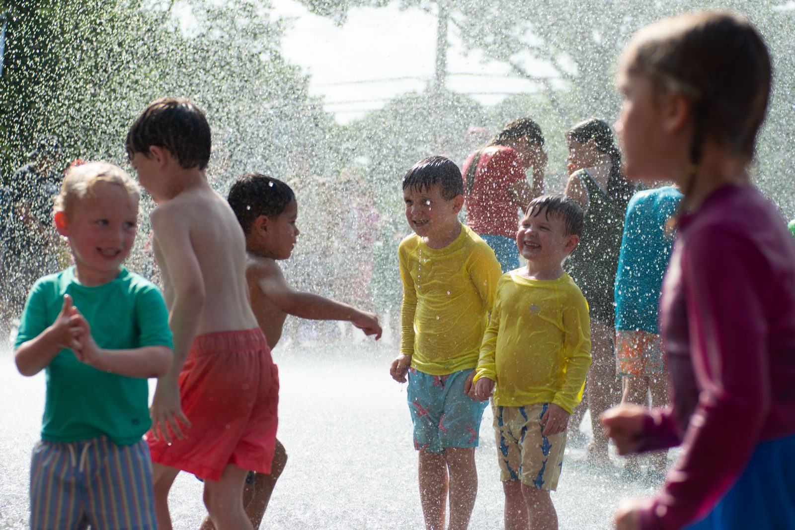 Kids laugh together in the falling water.