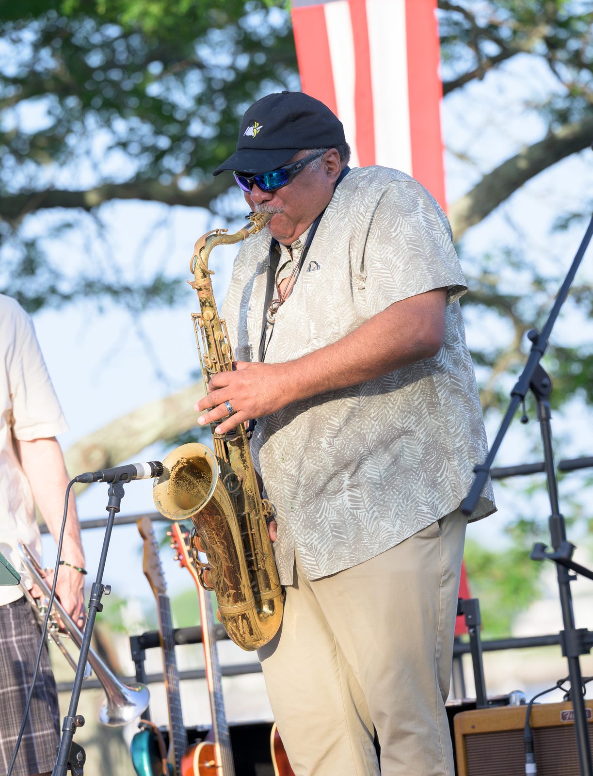 A saxophonist takes his turn out front, the lacquer worn from the bell of his horn.