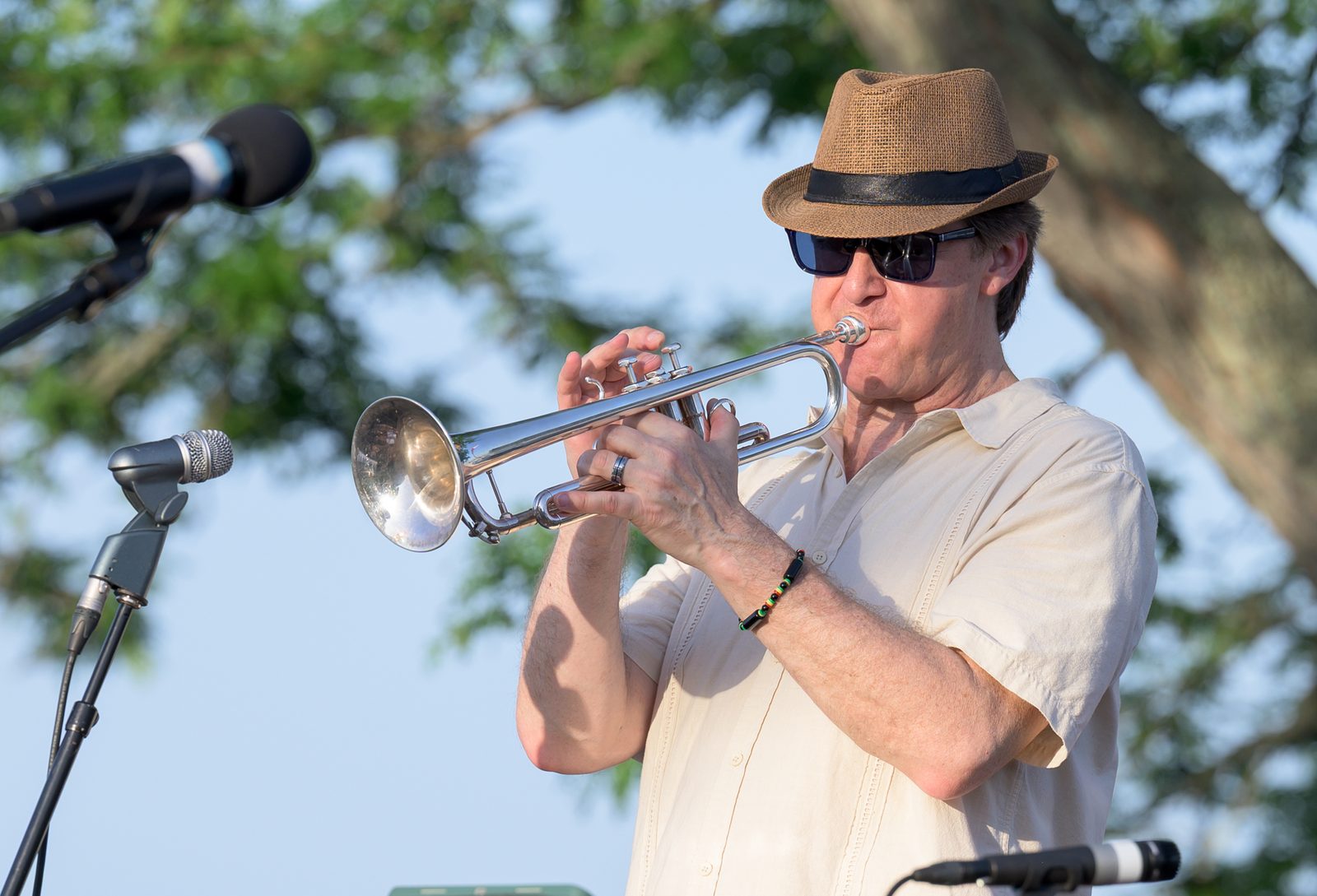 A trumpeter in a straw fedora leans into a solo at the front of the stage.