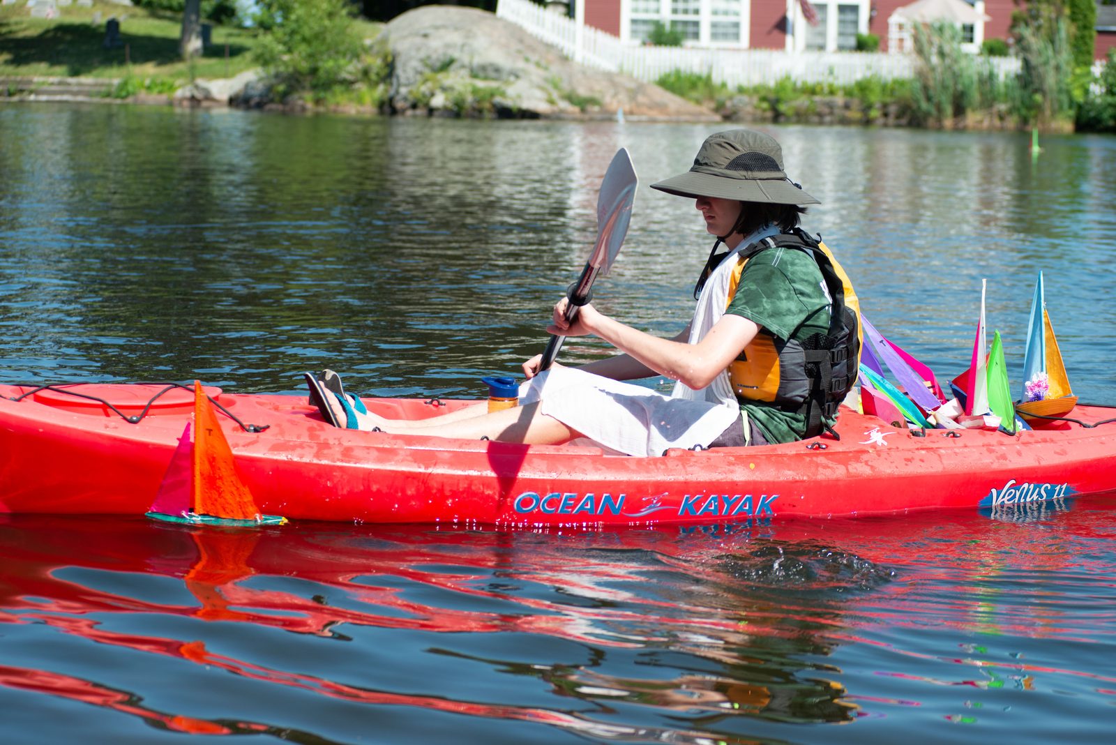 A paddler works a slow circuit in a kayak, playing retriever for the boats that drift out of reach.