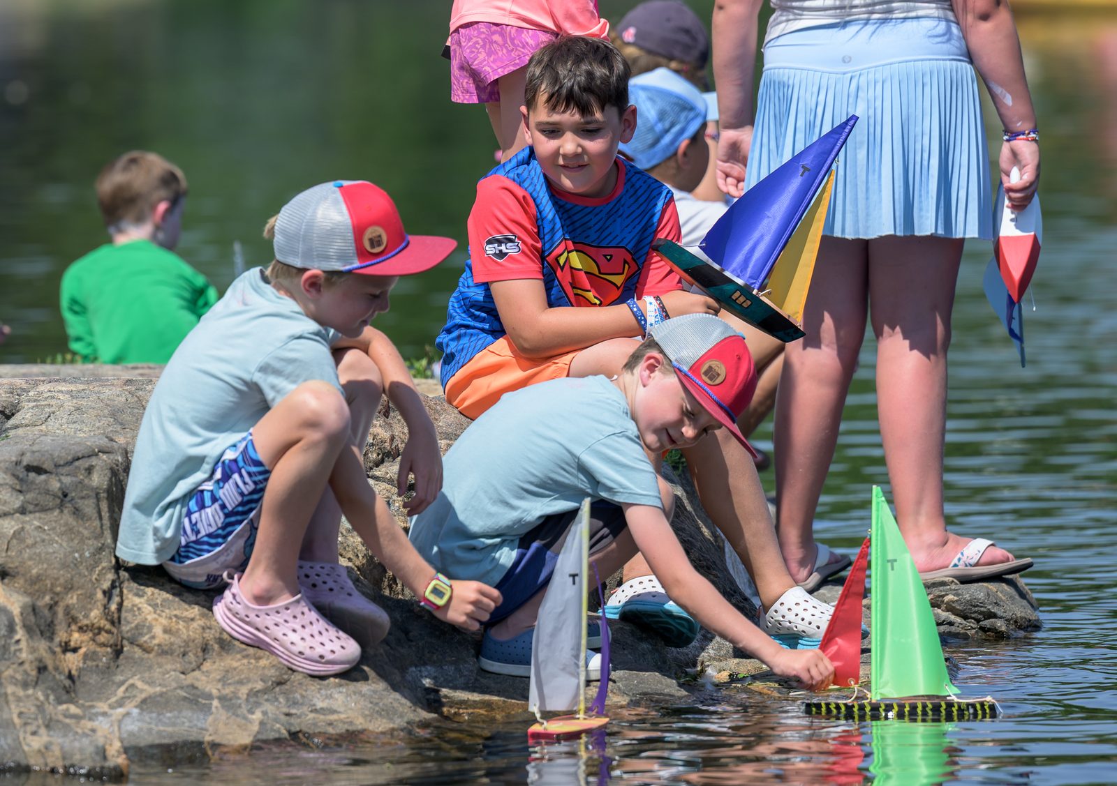 A young builder carries his boat down to the water’s edge.