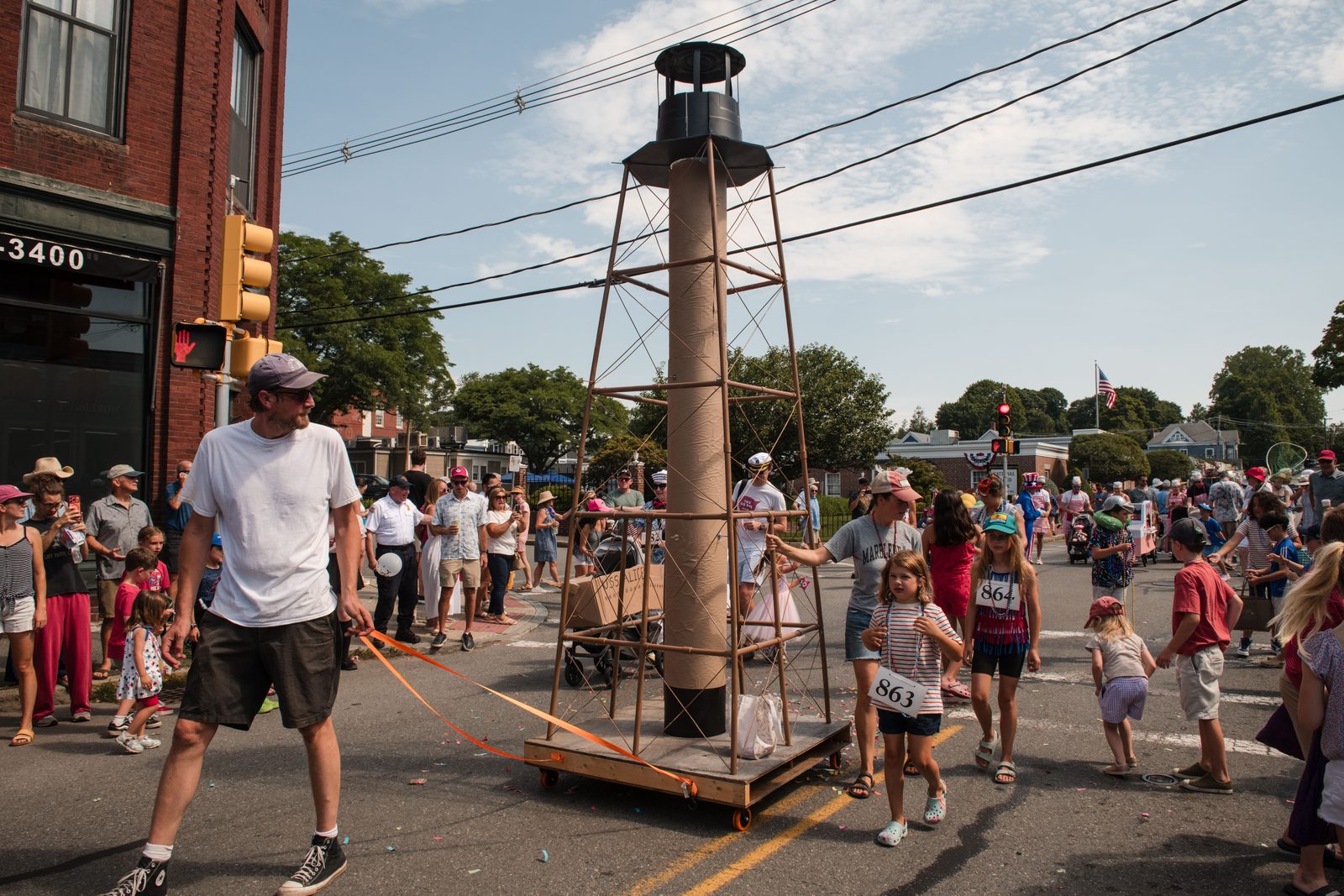 A papier-mâché replica of Marblehead Light — towed by School Committee member Henry Gwazda — rolls down the street on furniture dollies.