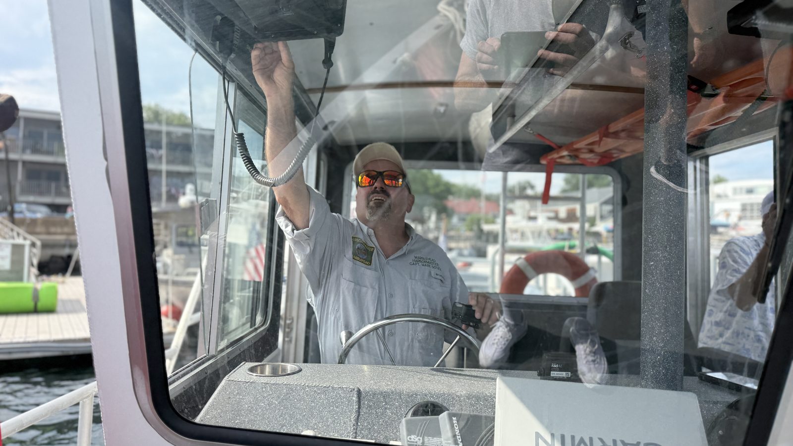 Aboard the Marblehead harbormaster’s launch, an officer works the radio while crossing the harbor.