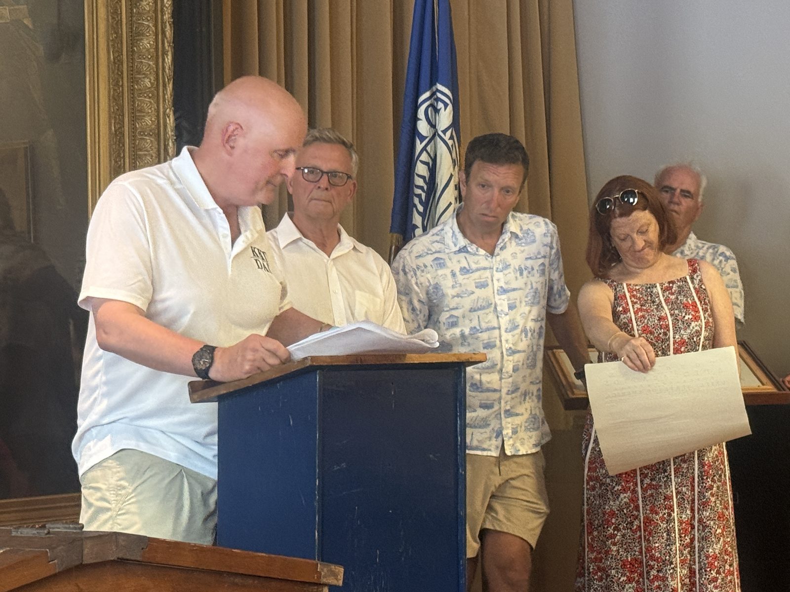 Members of the Select Board read the Declaration of Independence aloud at Abbot Hall, in the room that holds Archibald Willard’s ‘The Spirit of ’76.’
