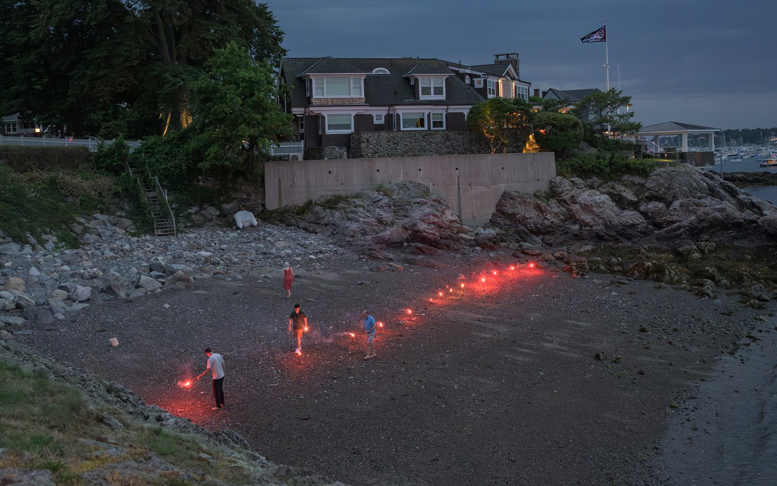 A line of flares burns down the beach as people set them along the tide line before the fireworks.